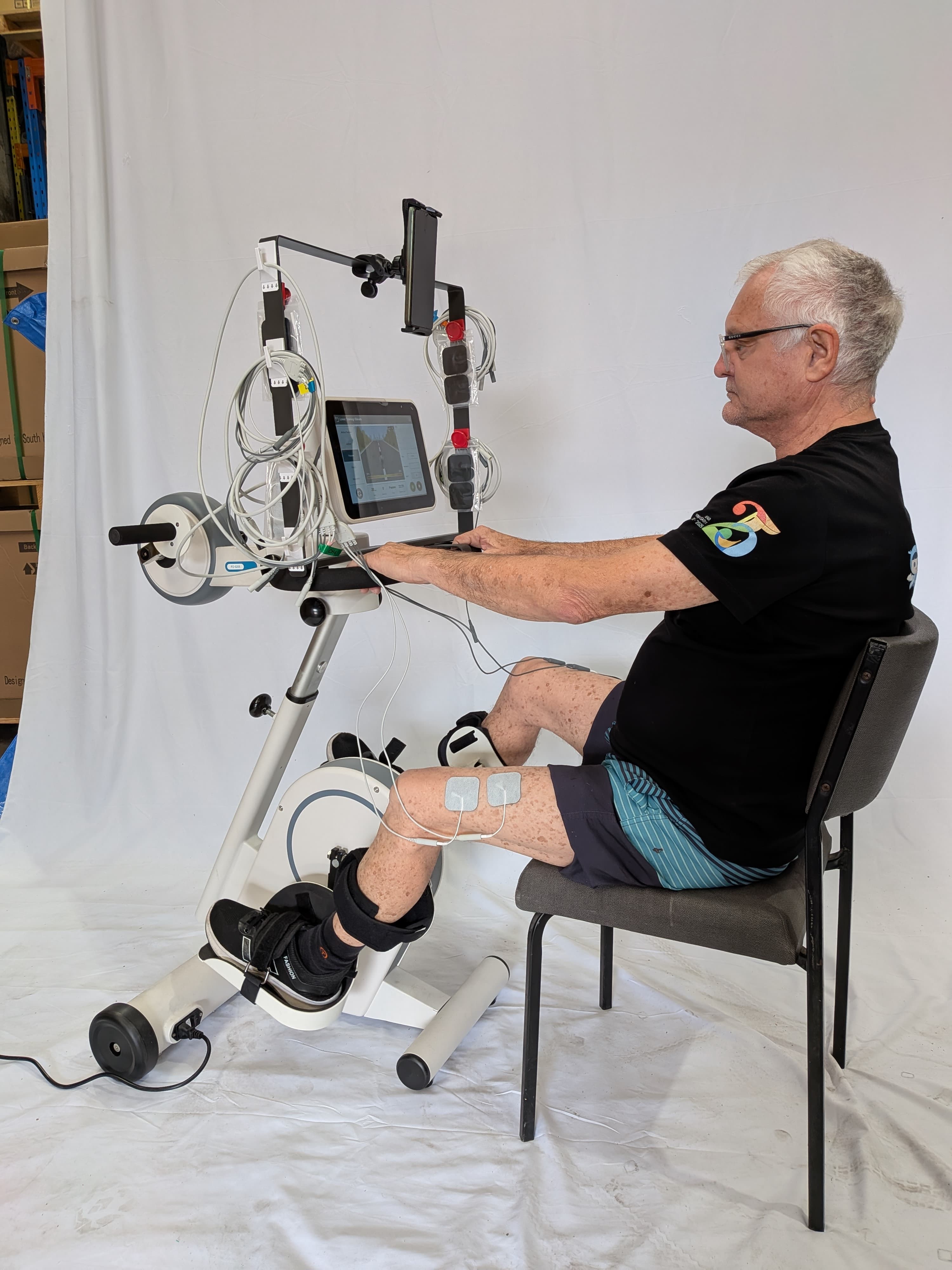 Person using a Supapedal Ultra FES trainer with stimulation electrodes on the leg
